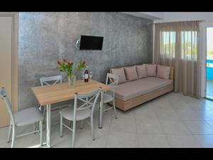a living room with a couch and a table with chairs at Pan Mare in Skala Sotiros