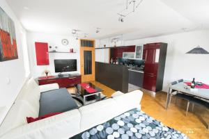 a living room with a white couch and a kitchen at RUBY Apartment Kobarid Private Sauna Retreat in Kobarid