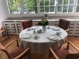 einen Tisch in einem Zimmer mit einem weißen Tischtuch in der Unterkunft Gästehaus Leipzig in Leipzig