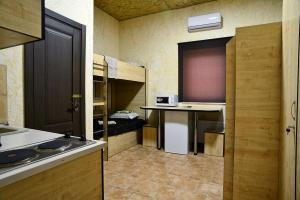 a kitchen with a sink and a desk and bunk beds at Logovo Hostel in Odesa