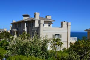 a house on a hill with the ocean in the background at Pinnacle Point - Golf Safari SA in Mossel Bay