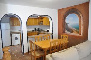 a kitchen and dining room with a table and a kitchen with the ocean at Costahispania 308 in Gran Alacant