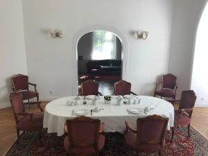 a dining room with a white table and chairs at Gästehaus Leipzig in Leipzig