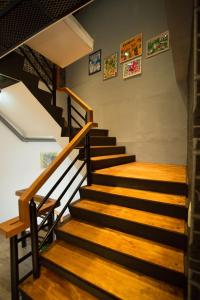 a staircase in a building with wooden floors and paintings on the wall at Meng Yun Ge Hotel in Jiaoxi