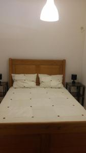 een bed met een houten hoofdeinde en 2 kussens bij Gaivota Sun in Portimão +28 foto's