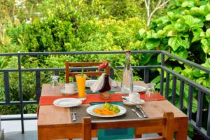 a wooden table with a plate of fruit on it at Spice Villa Thekkady in Thekkady