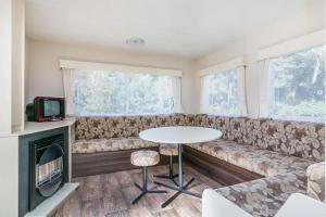 ein Wohnzimmer mit einem Sofa, einem Tisch und einem TV in der Unterkunft Oostappen Vakantiepark Blauwe Meer NV in Lommel