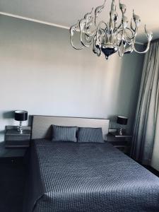 a bedroom with a bed and a chandelier at Apartamenty Dream of Bydgoszcz in Bydgoszcz