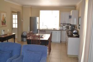 a kitchen and living room with a table and chairs at Pinnacle Point - Golf Safari SA in Mossel Bay