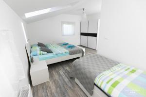 a white room with two beds and a bedskirts at Emerald Soca Apartment in Tolmin