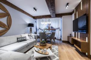 salon z kanapą i telewizorem w obiekcie Apartament Szymaszkowa Relax Ski Odkryj Zakopane w Zakopanem