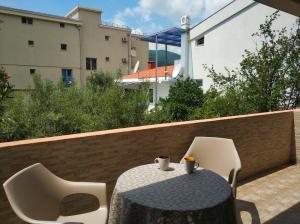 einen Tisch und Stühle auf einem Balkon mit Tisch und Stühlen in der Unterkunft Apartments Vila Anastasia in Budva