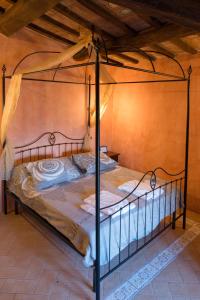 Castello Di Giomici في Valfabbrica: غرفة نوم بسرير مع ستارة معدنية