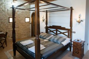 a bedroom with a canopy bed and a table at Castello Di Giomici in Valfabbrica