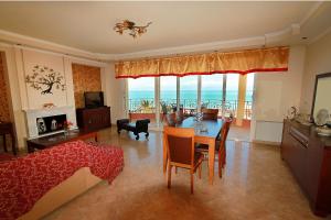 a living room with a table and a view of the ocean at Romanza Villa in Agios Stefanos