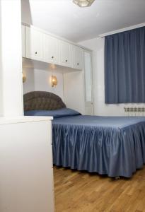 Apartment Pier في مدينة فارنا: غرفة نوم بسرير وملاءات زرقاء ونافذة