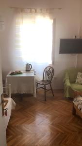 a living room with a table and a chair and a window at Apartment Vesna in Supetar