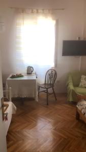 sala de estar con mesa, silla y ventana en Apartment Vesna, en Supetar