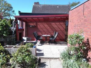 a patio with a table and chairs and a brick wall at FeWo24-Prasdorf in Prasdorf