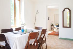 uma sala de jantar com uma mesa branca e cadeiras em Les pieds dans l'eau: Gîte Gervanne - Plage privée em Blacons