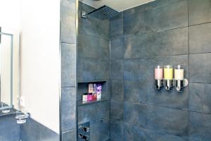 a bathroom with a shower with candles on the wall at Zwanestein Canal House in Amsterdam