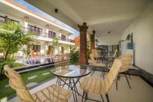 a balcony with a table and chairs and a pool at Lila Loka Homestay in Canggu