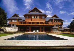 a large house with a pool in front of it at Hostería Isla Victoria Lodge in Isla Victoria