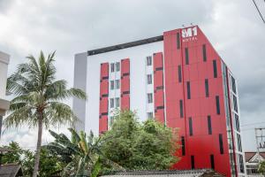 un edificio rojo y blanco con un cartel en él en M1 Hotel en Nakhon Si Thammarat