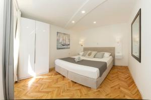 a bedroom with a large bed and a wooden floor at Palace apartment in Split