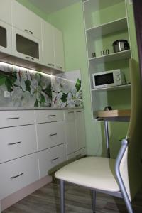 ベロクリハにあるКвартира 3-х комнатнаяの白いキャビネットと椅子付きのキッチン