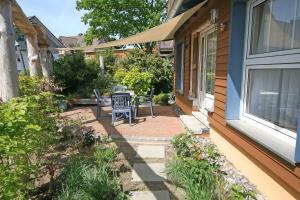 a patio with a table and chairs next to a house at Ferienhaus Thea mit Terrasse in Baabe