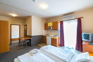 a hotel room with two beds and a television at Beach Hotel in Si&oacute;fok
