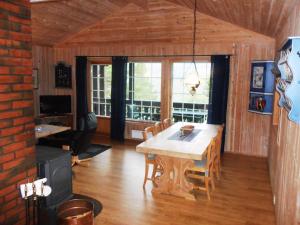 comedor con mesa de madera y sillas en Hogstul Hytter - Knatten - 3 Bedroom Cottage, en Tuddal