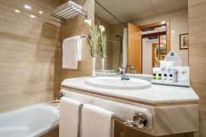 a bathroom with a sink and a tub at Avenida Hotel in Almería