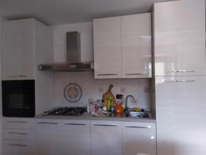 a white kitchen with white cabinets and a sink at La Quiete in Ponte Caffaro