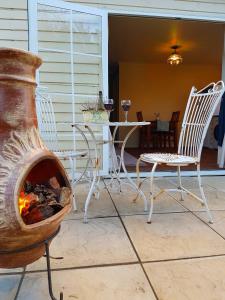 a fire pit on a patio with chairs and a table at Glascroft Gardens - Bed & Breakfast in Patea