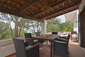 an outdoor patio with a wooden table and chairs at Villa Maratea in Marina