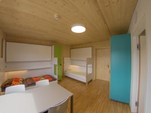 a room with two beds and a table and chairs at Hostel Salzburg-Wals in Salzburg