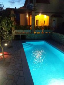 a swimming pool in front of a house at night at Holiday apartment Boko in Pinezici