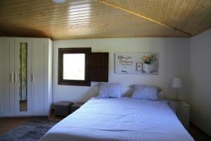 La TeijeiraにあるCasa Jucaの木製の天井のベッドルーム(白い大型ベッド1台付)