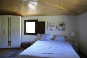 a bedroom with a large white bed with a wooden ceiling at Casa Juca in La Teijeira