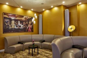 a waiting room with a couch and a table at Hollywood Media Hotel am Kurfürstendamm in Berlin