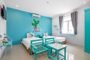 a blue and white room with two beds and a table at RAON Apartment & Hotel in Da Nang