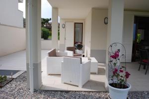 Un patio con muebles blancos y flores en una maceta. en Villa Sophora, en Moniga del Garda 31 fotos más