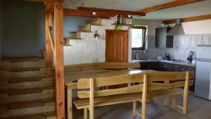 a kitchen with a wooden table and chairs and a staircase at Ptasi Folwark in Dolistowo
