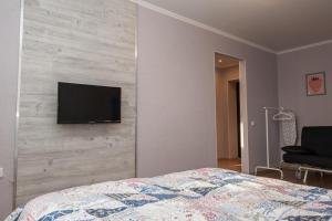 チュメニにあるСчастливая квартира на Самарцеваのベッドルーム1室(ベッド1台、壁にテレビ付)