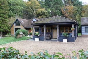 een huis met een blauw huis met een veranda bij The Devils Cradle in Farnham