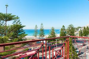 a balcony with a view of a street and the ocean at Mad Monkey Coogee Beach in Sydney