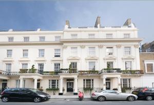 a white building with cars parked in front of it at Paddington Court Executive Rooms in London