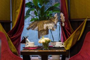 einen Tisch mit zwei Tassen und einer Pflanze darauf. in der Unterkunft Hotel Campiello in Venedig